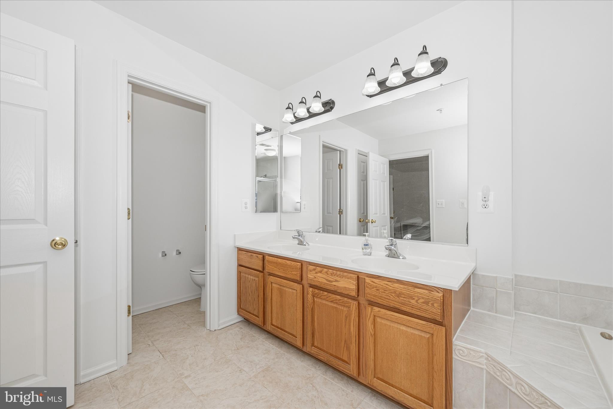 21 Inkberry Circle Gaithersburg, MD 20877 - Photo 33 of 51 a bathroom with a double vanity sink and mirror