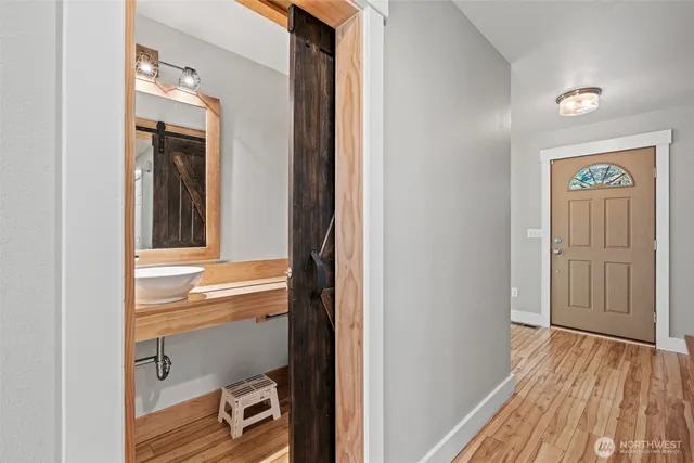 a view of a hallway with wooden floor and closet