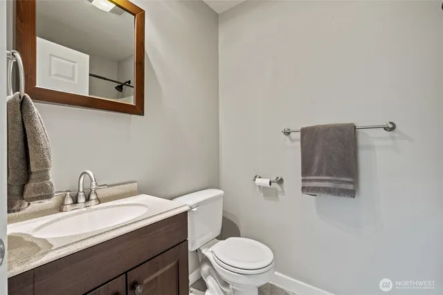 a bathroom with a toilet a sink and mirror