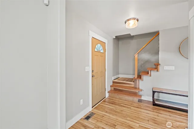 a view of a hallway with wooden floor and stairs