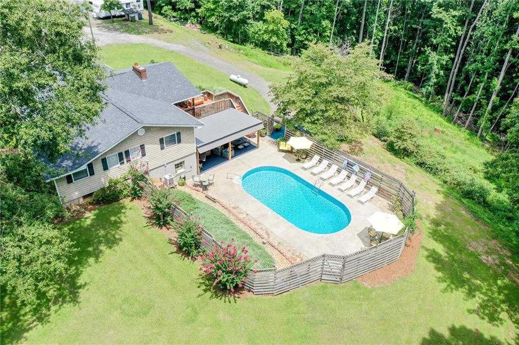 an aerial view of a house with outdoor space pool seating area and yard