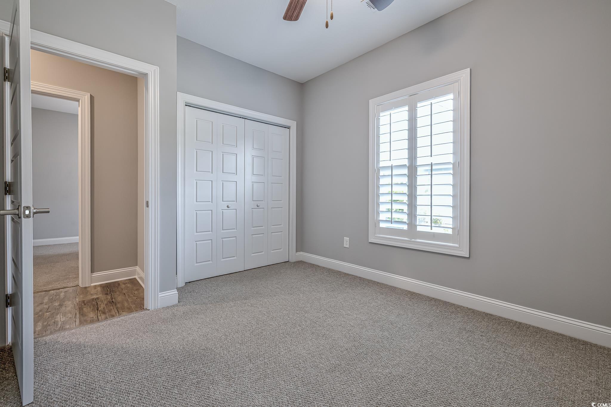 648 Sunnyside Drive, Unit 102 Murrells Inlet, SC 29576 - Photo 11 of 21 Unfurnished bedroom featuring carpet floors, baseboards, a closet, and ceiling fan