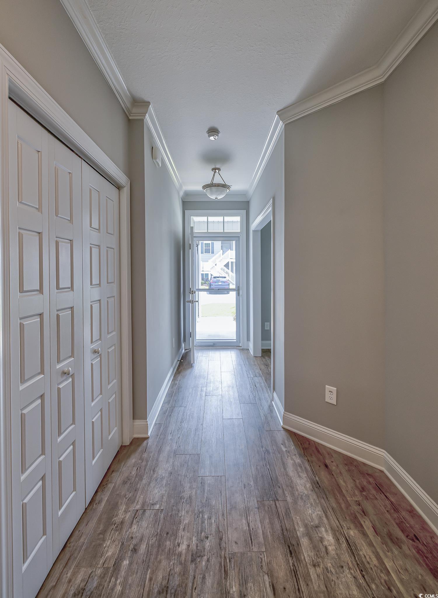 648 Sunnyside Drive, Unit 102 Murrells Inlet, SC 29576 - Photo 13 of 21 Hallway featuring wood finished floors, ornamental molding, and baseboards
