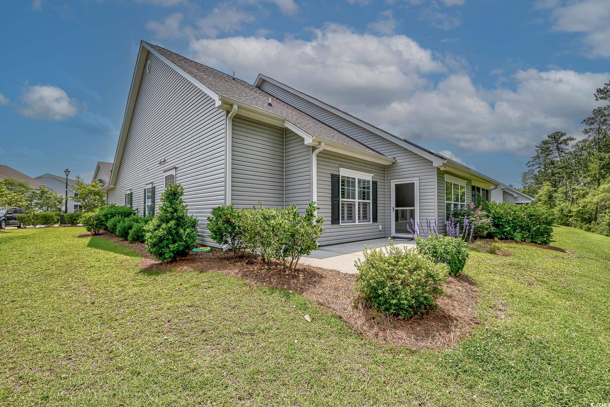648 Sunnyside Drive, Unit 102 Murrells Inlet, SC 29576 - Photo 18 of 21 View of side of home with a yard and a patio area