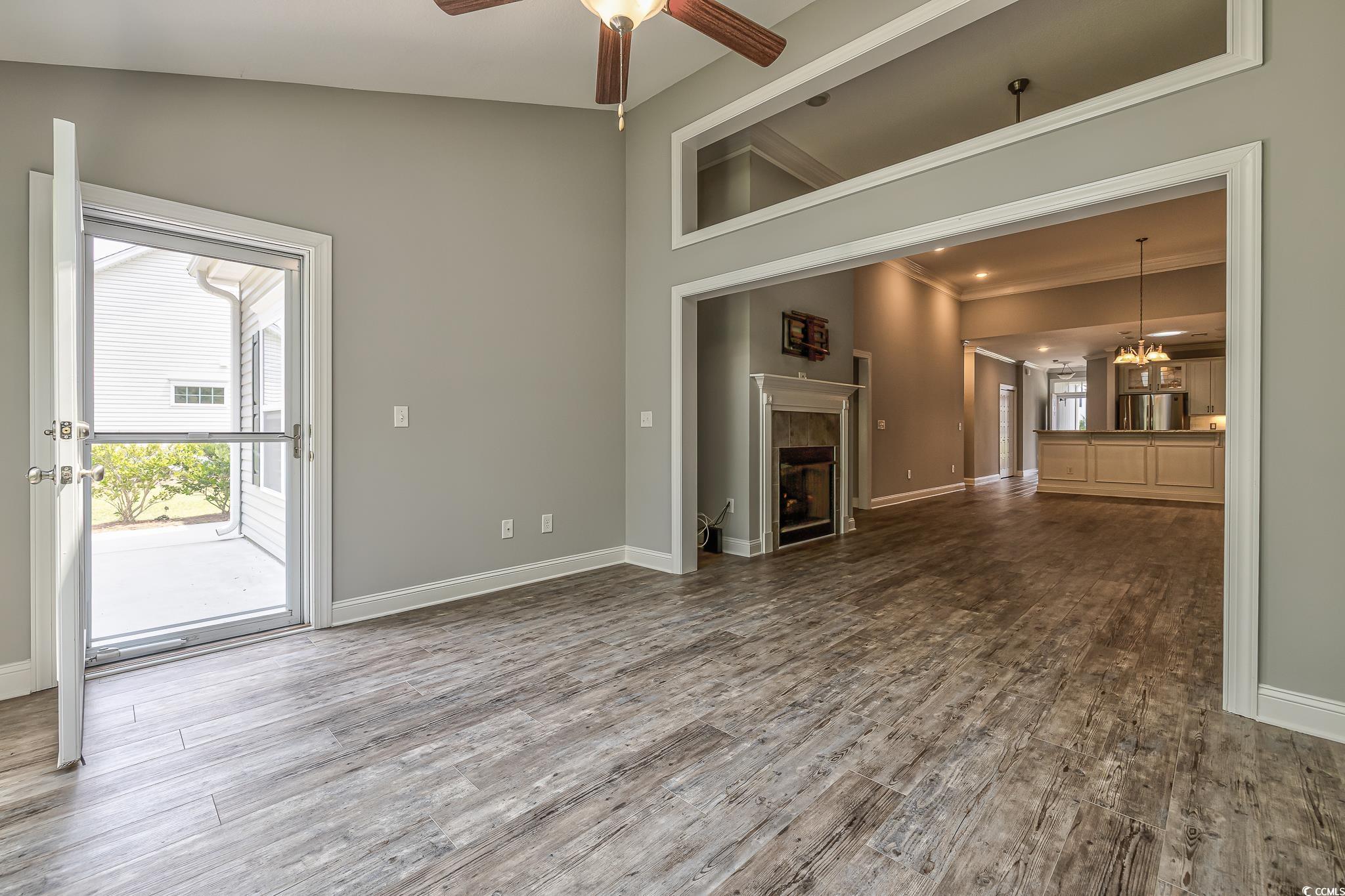 648 Sunnyside Drive, Unit 102 Murrells Inlet, SC 29576 - Photo 20 of 21 Unfurnished living room with a ceiling fan, baseboards, a high end fireplace, wood finished floors, and ornamental molding