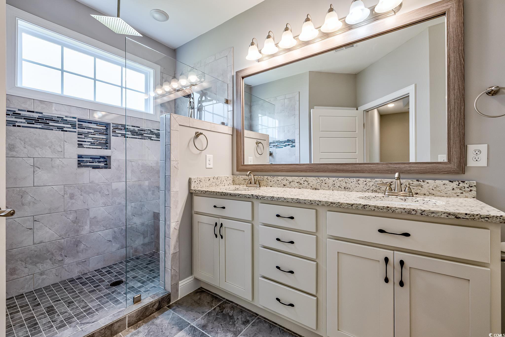648 Sunnyside Drive, Unit 102 Murrells Inlet, SC 29576 - Photo 8 of 21 Bathroom with double vanity and a stall shower