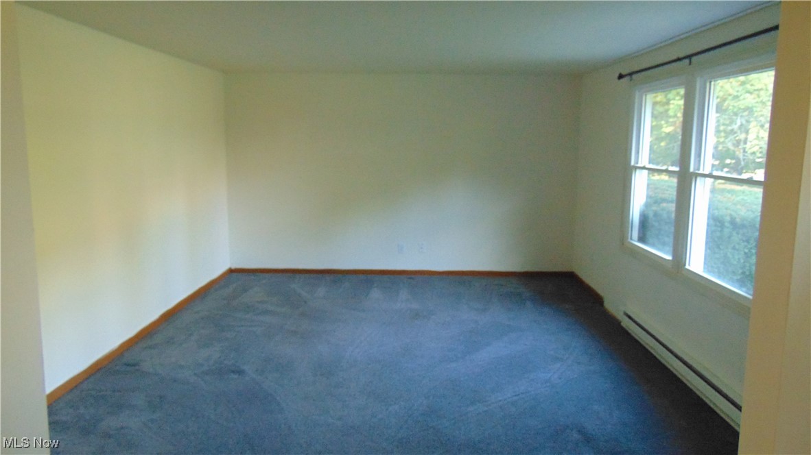 4970 Bryenton Road Litchfield, OH 44253 - Photo 8 of 33 Empty room with baseboard heating and dark colored carpet