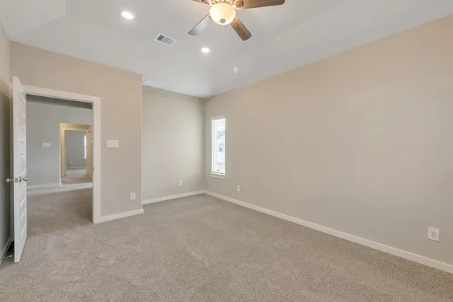 an empty room with a ceiling fan and a window