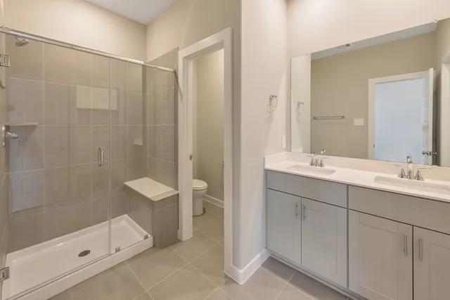 a bathroom with a double vanity sink toilet and shower