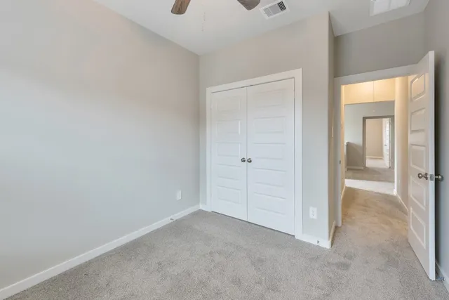 an empty room with a window and a fan