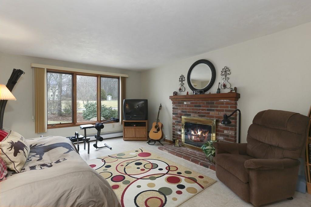 8 Pheasant Hill Road Bellingham, MA 02019 - Photo 6 of 15 a living room with furniture a fireplace a window and a flat screen tv