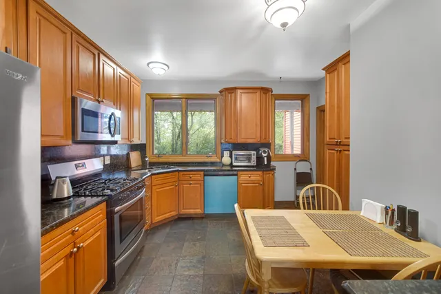 a kitchen with stainless steel appliances granite countertop a stove a sink dishwasher and a refrigerator