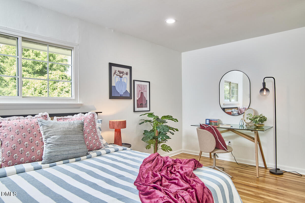 2613 McNeil Street, Unit E Raleigh, NC 27608 - Photo 19 of 28 a bedroom with a bed a potted plant and a large window