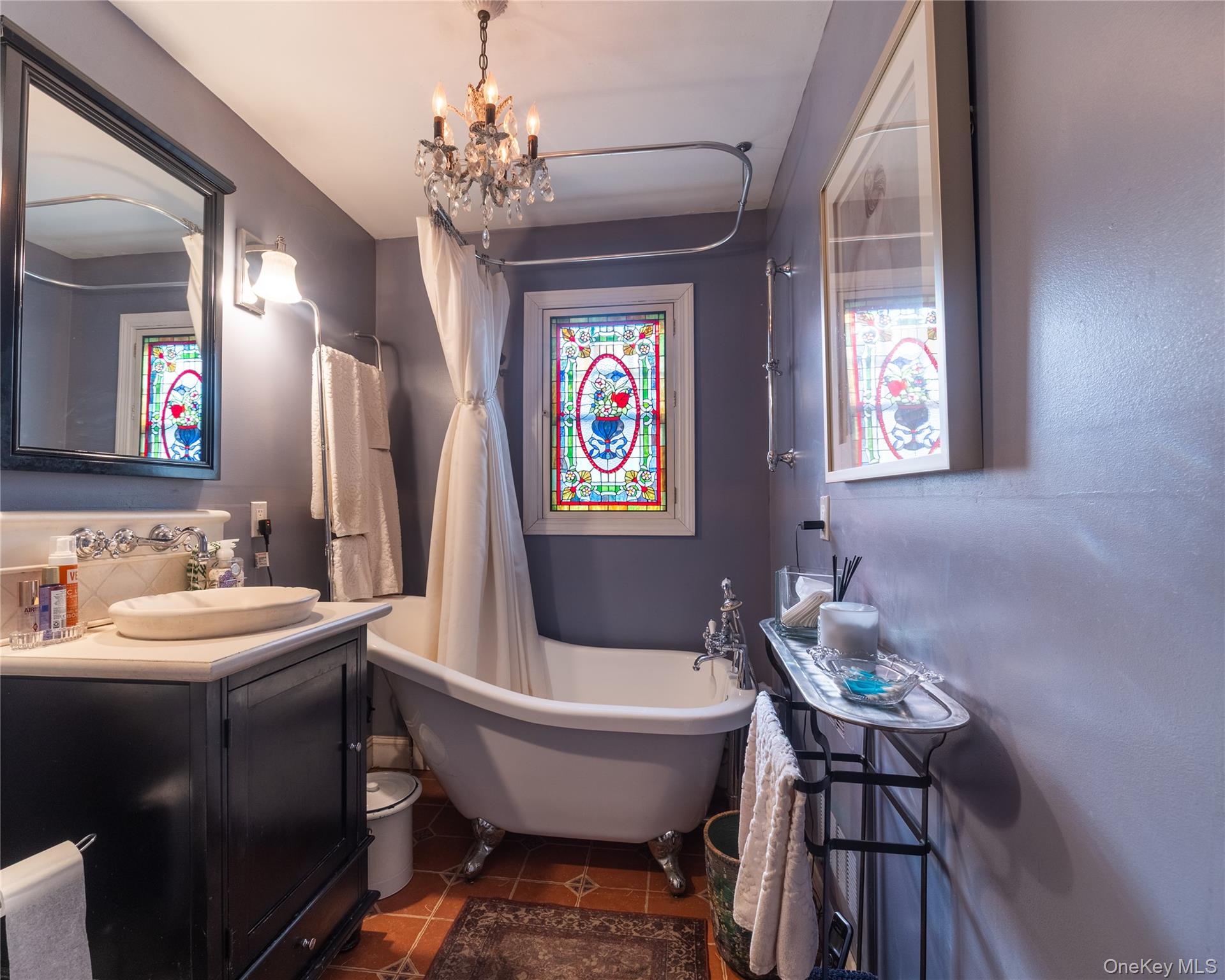 8 Ridgeland Terrace Rye, NY 10580 - Photo 15 of 22 Bathroom with dark tile patterned flooring, vanity, a chandelier, and a combined bath / shower with freestanding tub