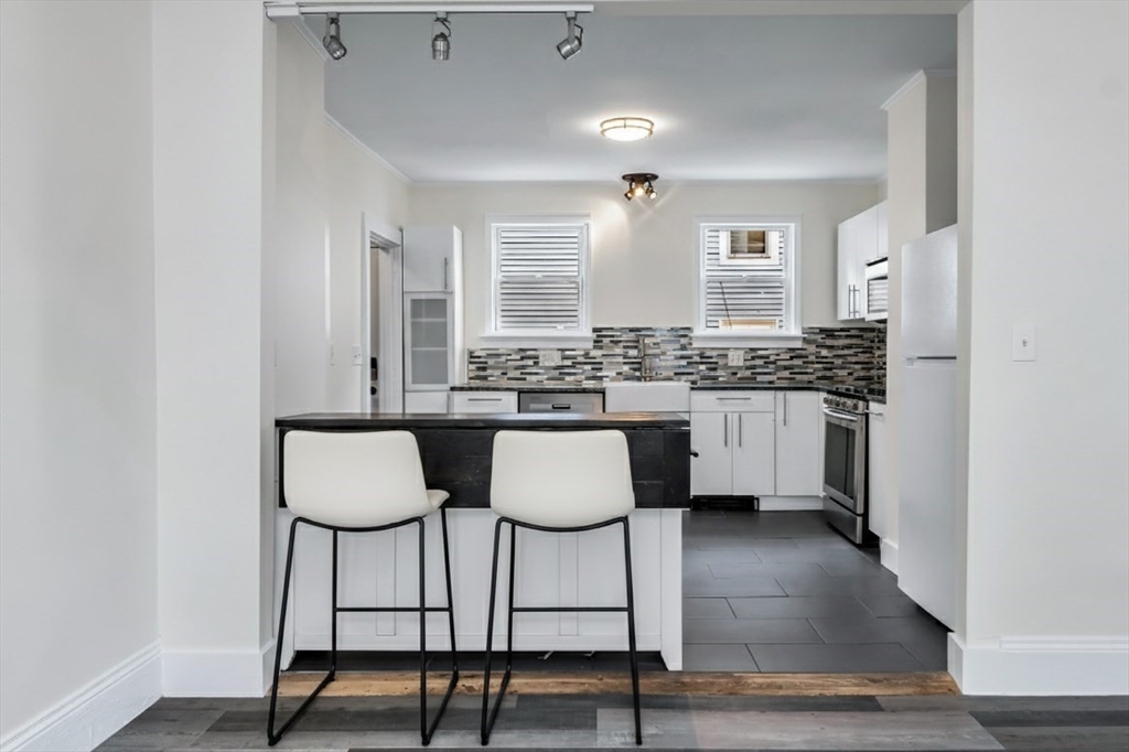 6 Dexter Street Haverhill, MA 01830 - Photo 12 of 42 a kitchen with granite countertop a table chairs stove and cabinets