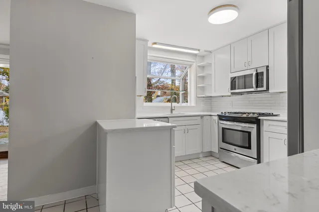 a kitchen with granite countertop a stove top oven microwave and a refrigerator