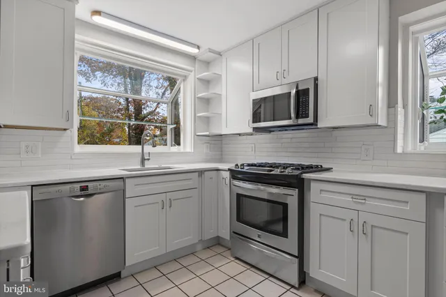 a kitchen with cabinets stainless steel appliances and a window
