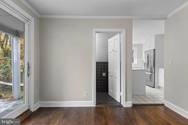 a view of a hallway with wooden floor and a livingroom