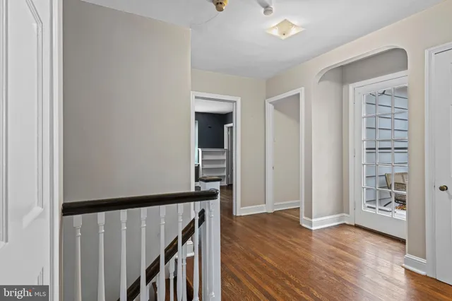 a view of a hallway with wooden floor and stairs