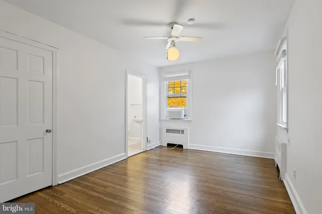 a view of empty room with wooden floor