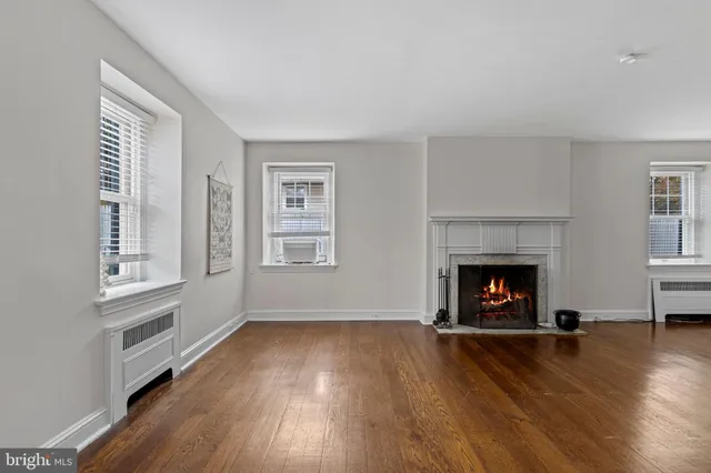an empty room with windows and a fireplace