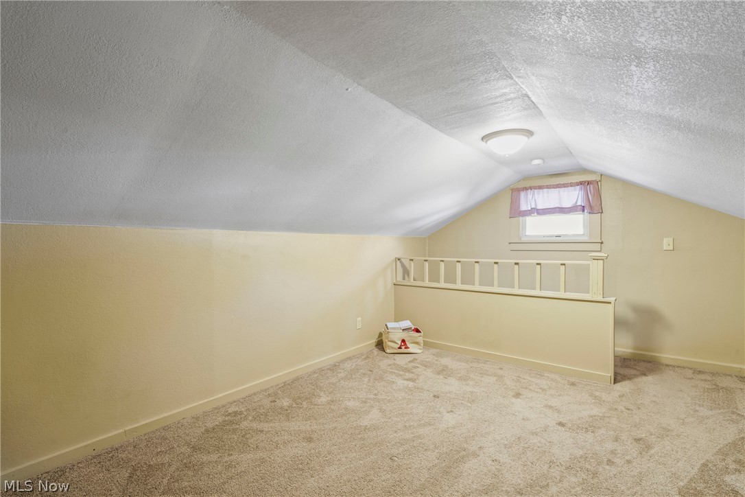 629 Clinton Street Niles, OH 44446 - Photo 24 of 50 Carpeted loft space featuring sloped ceilings, a single window, and a wall-mounted light fixture