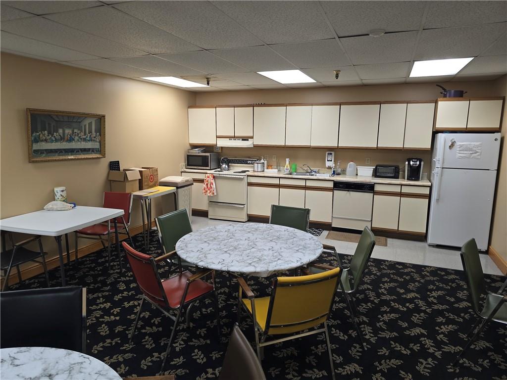 1987 Centurion Drive, Unit 202 Pittsburgh, PA 15221 - Photo 22 of 27 a kitchen with a dining table chairs and white appliances