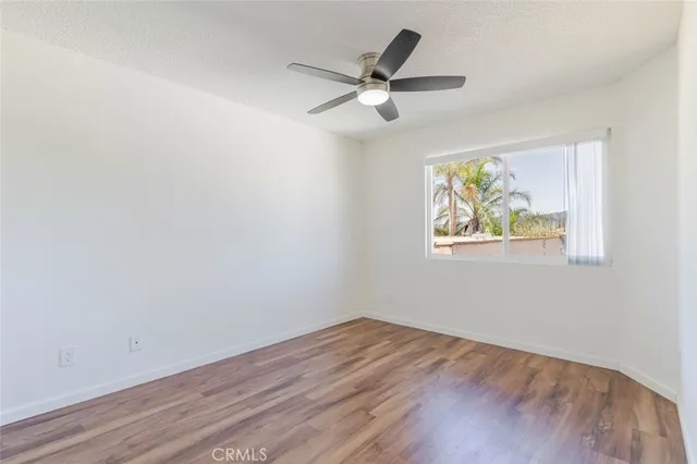 a view of a big room with wooden floor and windows
