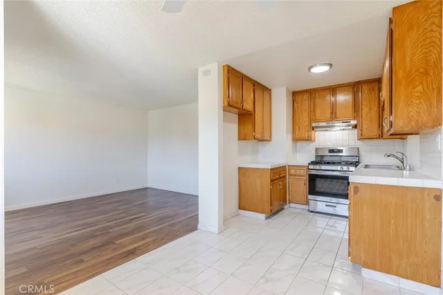 a kitchen with granite countertop a stove a sink and a microwave