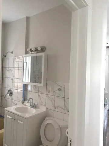 a bathroom with a toilet a sink and mirror