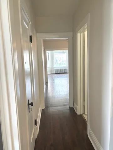 a view of a hallway with wooden floor and closet
