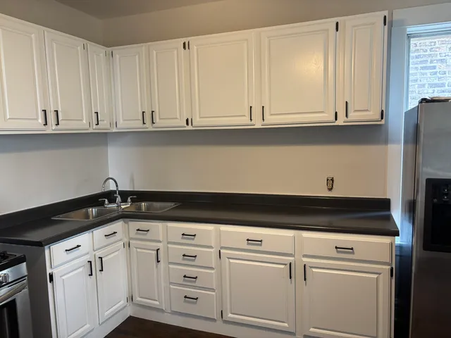 a kitchen with granite countertop white cabinets and white appliances