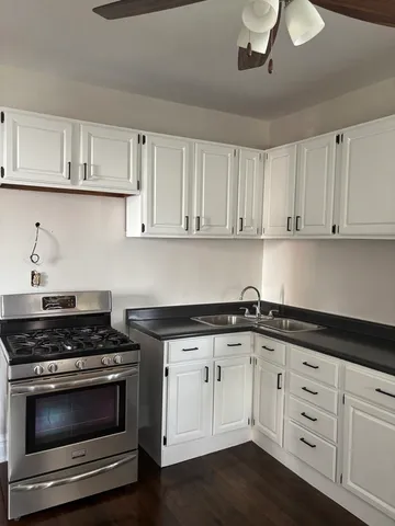 a kitchen with white cabinets and appliances