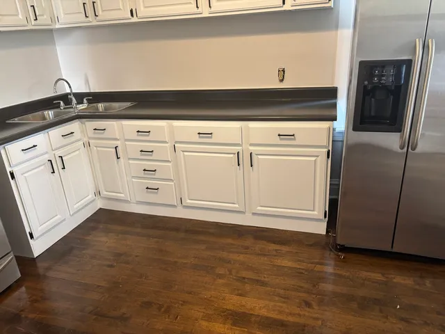 a kitchen with granite countertop a sink cabinets and stainless steel appliances