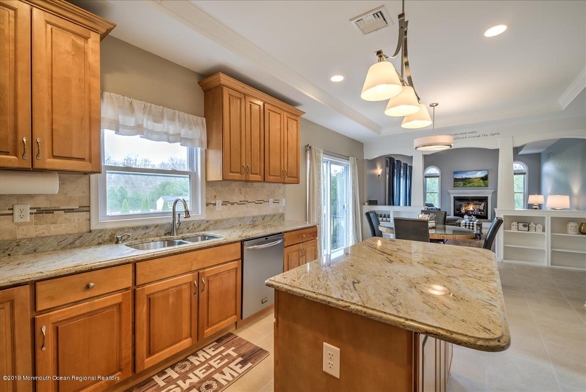 130 Crine Road Morganville, NJ 07751 - Photo 12 of 46 a kitchen with granite countertop kitchen island a sink stainless steel appliances and windows