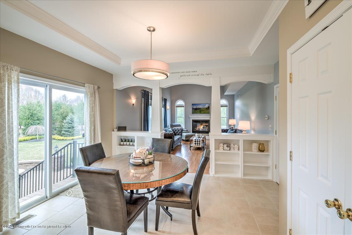 130 Crine Road Morganville, NJ 07751 - Photo 14 of 46 a view of a dining room with furniture wooden floor and chandelier