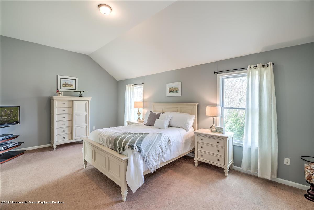 130 Crine Road Morganville, NJ 07751 - Photo 26 of 46 a spacious bedroom with a bed lamp and a window