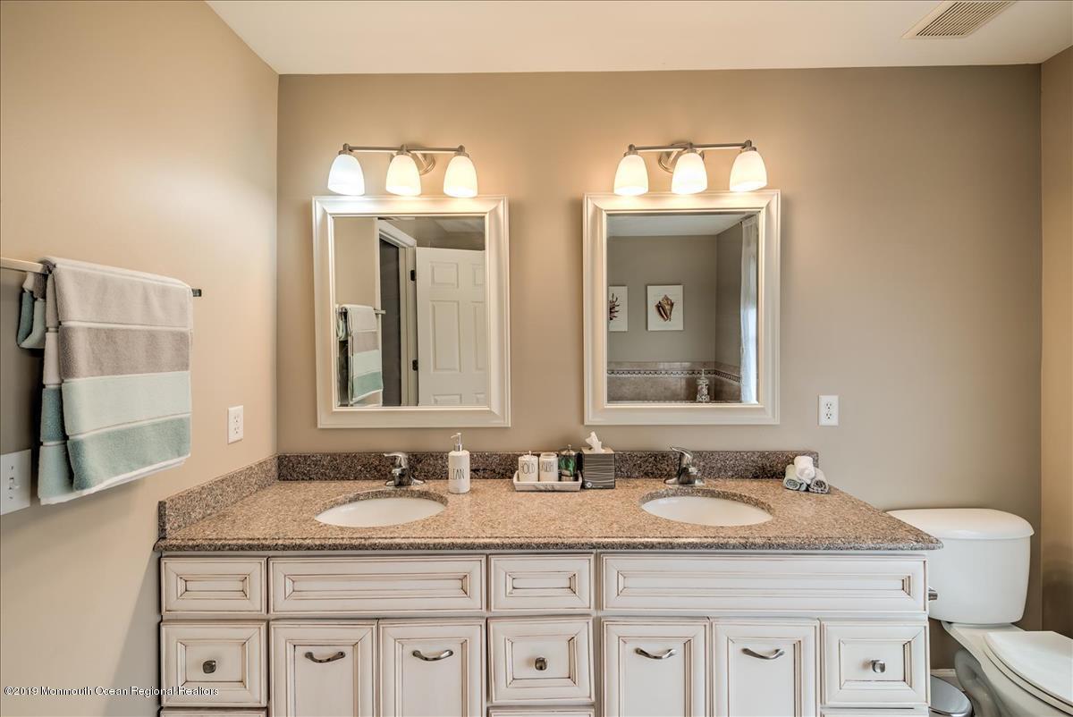 130 Crine Road Morganville, NJ 07751 - Photo 28 of 46 a bathroom with double sink and a mirror