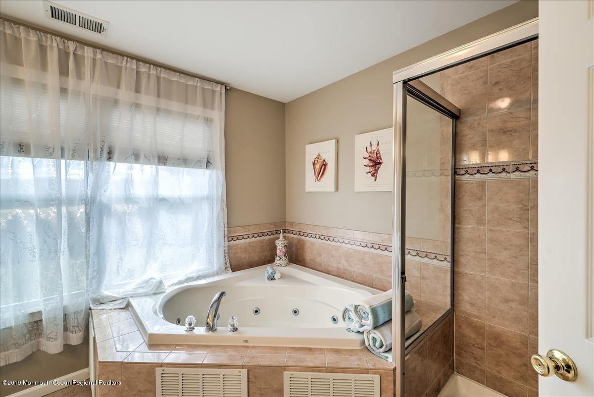130 Crine Road Morganville, NJ 07751 - Photo 29 of 46 a bathroom with a tub and shower
