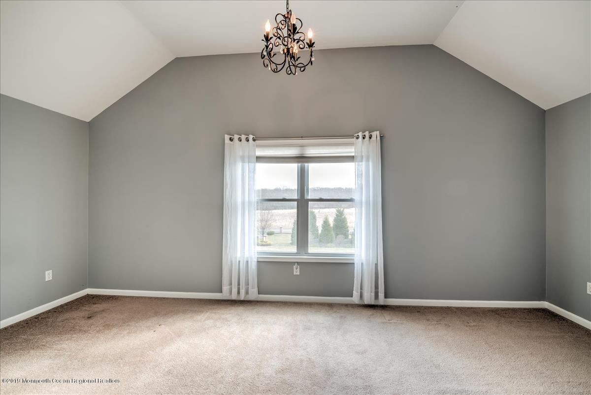 130 Crine Road Morganville, NJ 07751 - Photo 34 of 46 an empty room with chandelier fan and windows