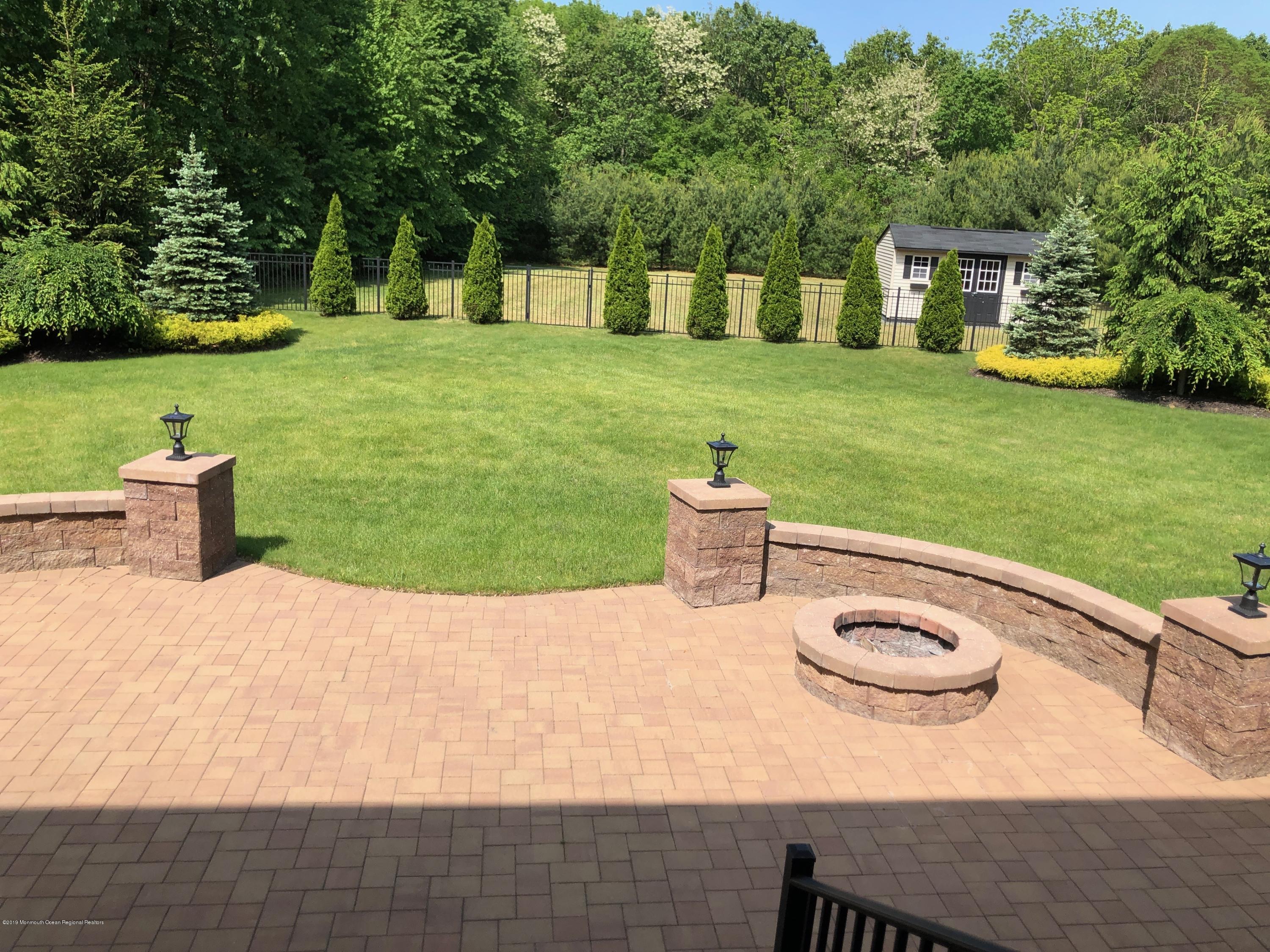 130 Crine Road Morganville, NJ 07751 - Photo 43 of 46 a view of a backyard with table and chairs potted plants and large tree