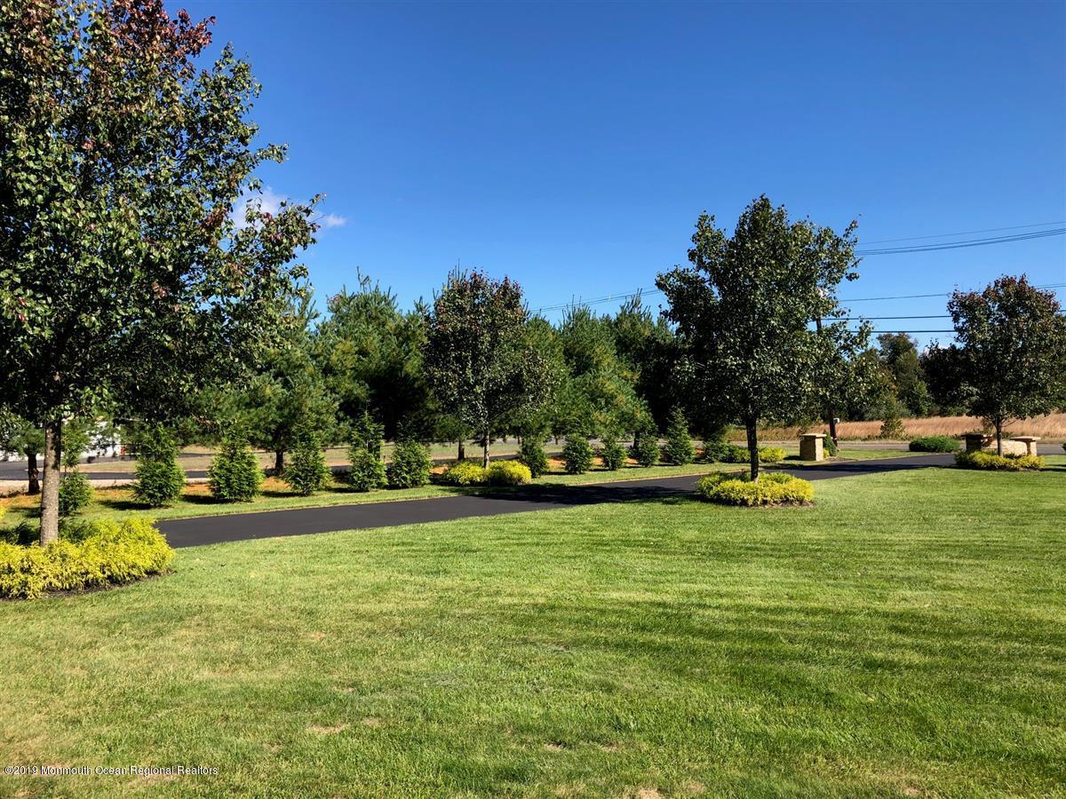 130 Crine Road Morganville, NJ 07751 - Photo 5 of 46 a view of a swimming pool with a garden and trees
