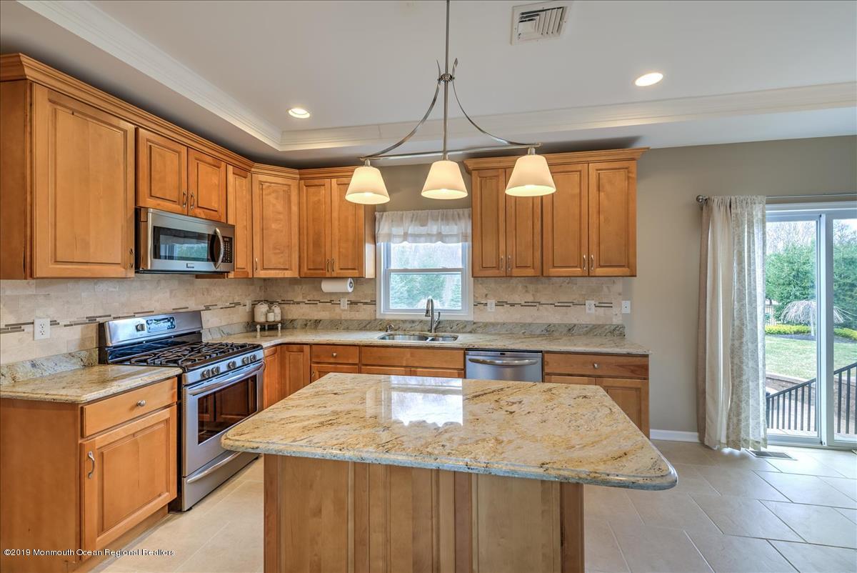 130 Crine Road Morganville, NJ 07751 - Photo 10 of 46 a kitchen with stainless steel appliances granite countertop a sink a stove and cabinets