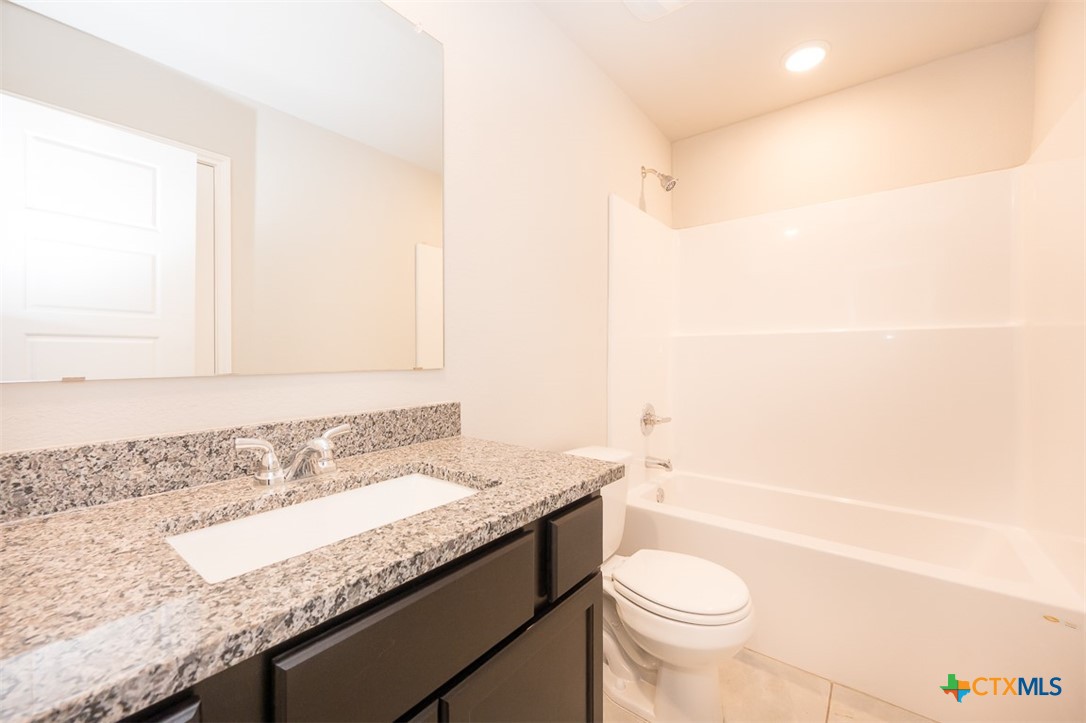 113 Lazy Lizzy Road Jarrell, TX 76537 - Photo 22 of 29 a bathroom with a granite countertop sink a toilet and shower