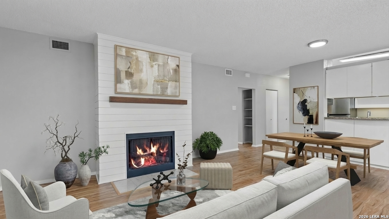8642 Fredericksburg Road, Unit 405 San Antonio, TX 78240 - Photo 12 of 24 a living room with furniture a fireplace and a wall painting