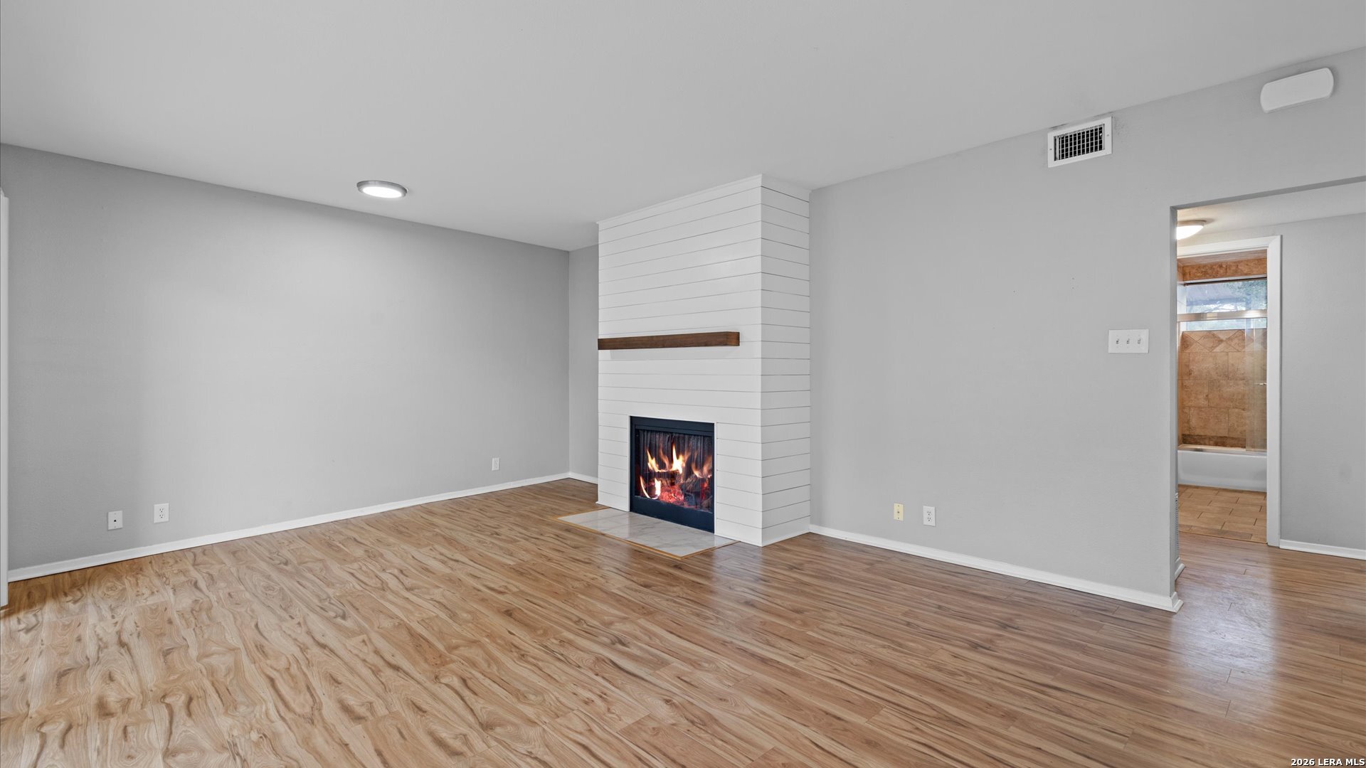 8642 Fredericksburg Road, Unit 405 San Antonio, TX 78240 - Photo 13 of 24 a view of an empty room with wooden floor fireplace and a window