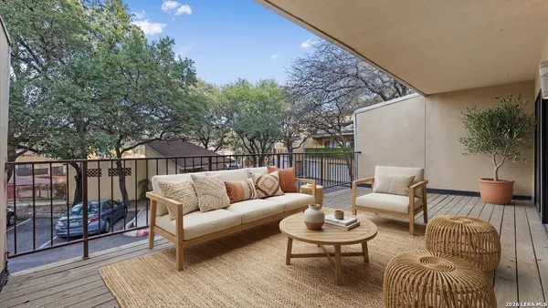 a balcony with furniture and wooden floor