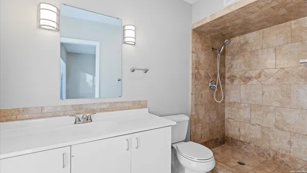 a bathroom with a sink a toilet and shower