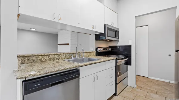 a kitchen with stainless steel appliances granite countertop a sink stove and microwave