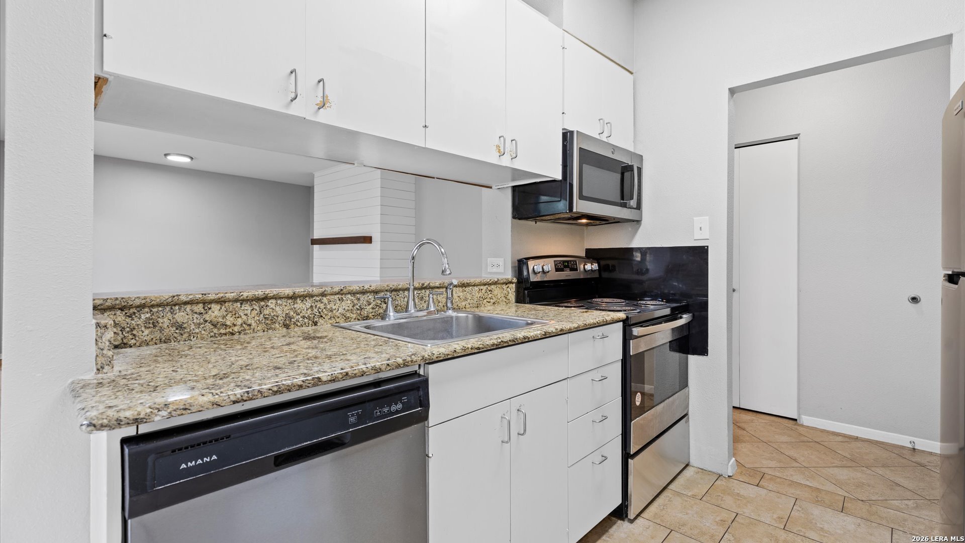8642 Fredericksburg Road, Unit 405 San Antonio, TX 78240 - Photo 4 of 24 a kitchen with stainless steel appliances granite countertop a sink stove and microwave